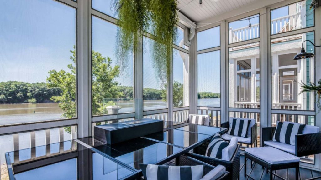 Curved glass sunroom with garden views and metal furniture