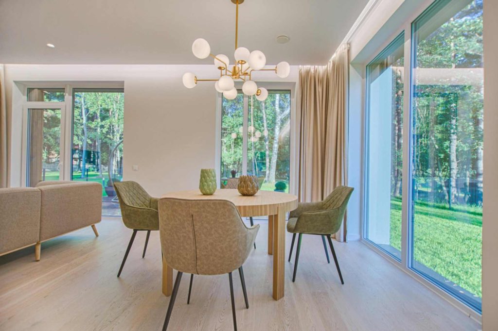 Bright sunroom with large aluminium glass panels and green outdoor view