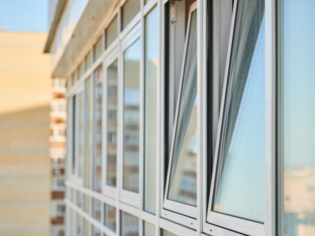 Tilt-in windows on the upper floors of a modern apartment building