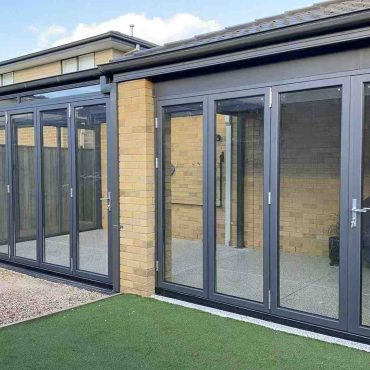 Modern backyard with glass doors and artificial grass