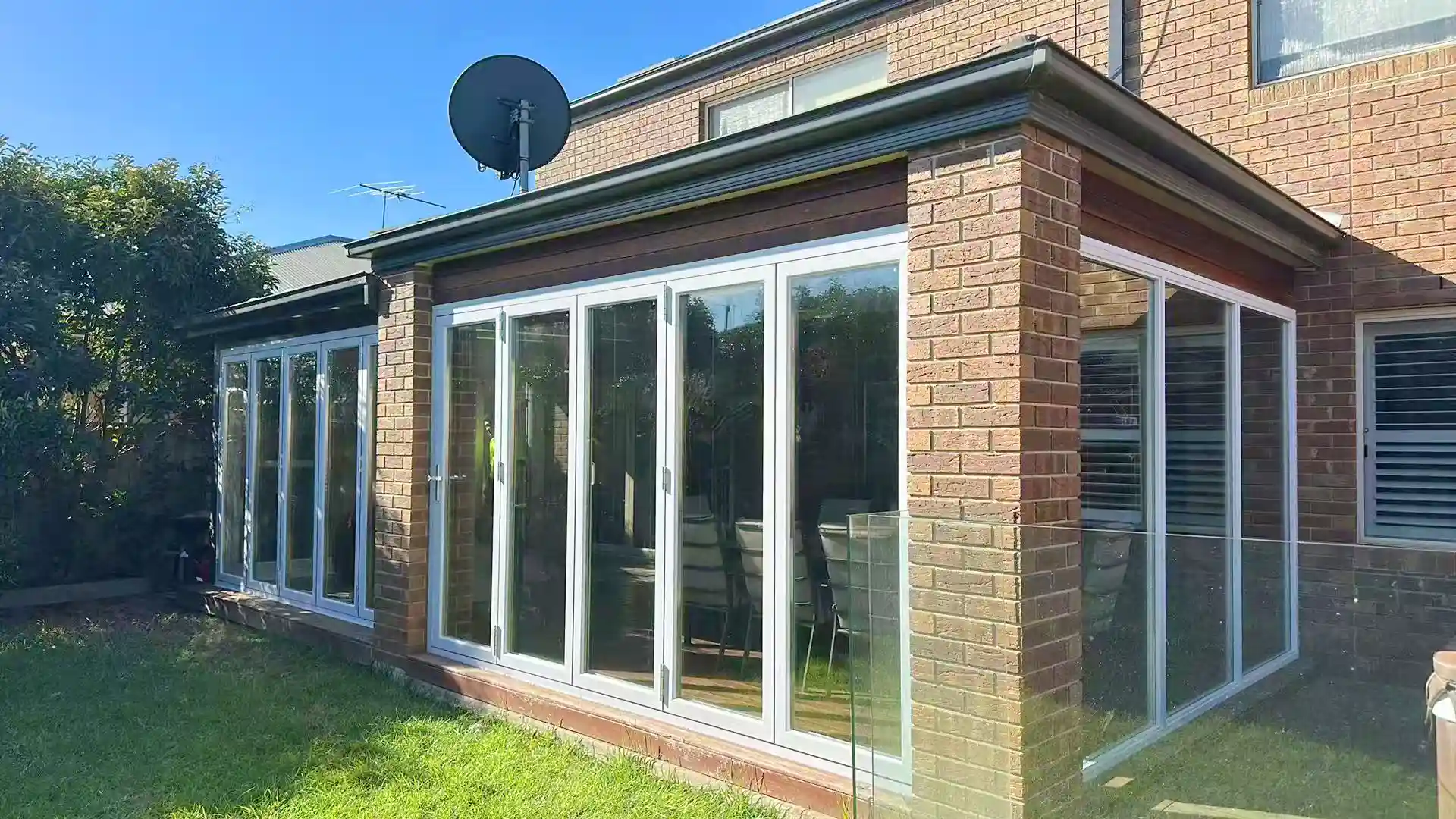 Double-glazed tilt-sliding windows across the rear elevation of a Melbourne brick home