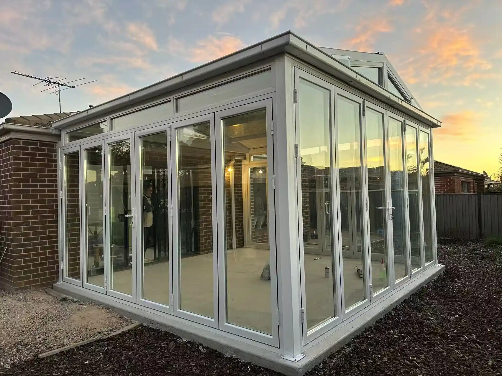 Finished glass sunroom extension at dusk