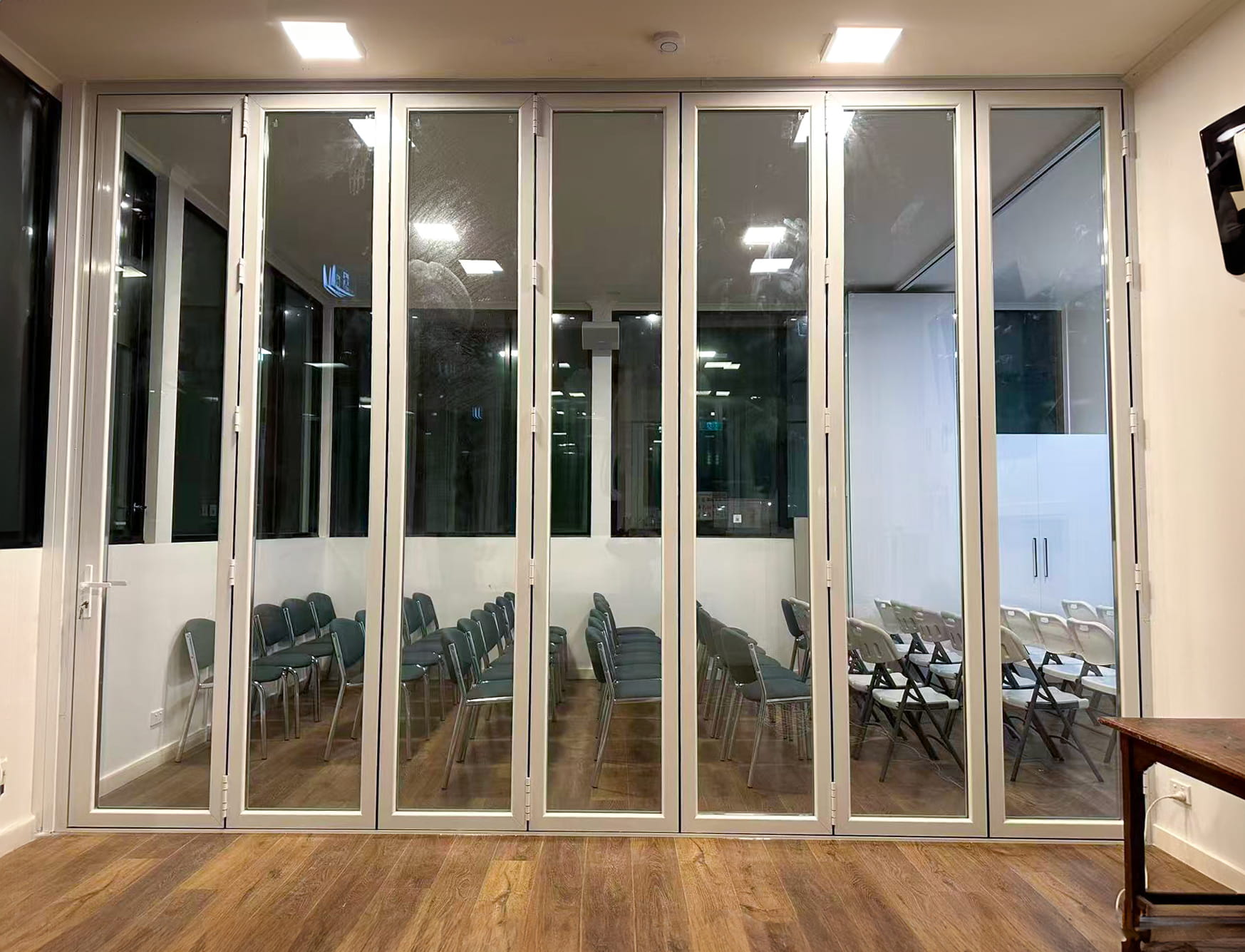 Installer assembling a large folding glass partition inside a building