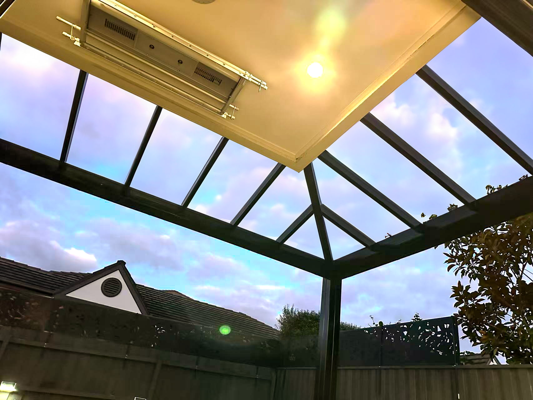 Installer assembling the roof structure of an aluminium sunroom