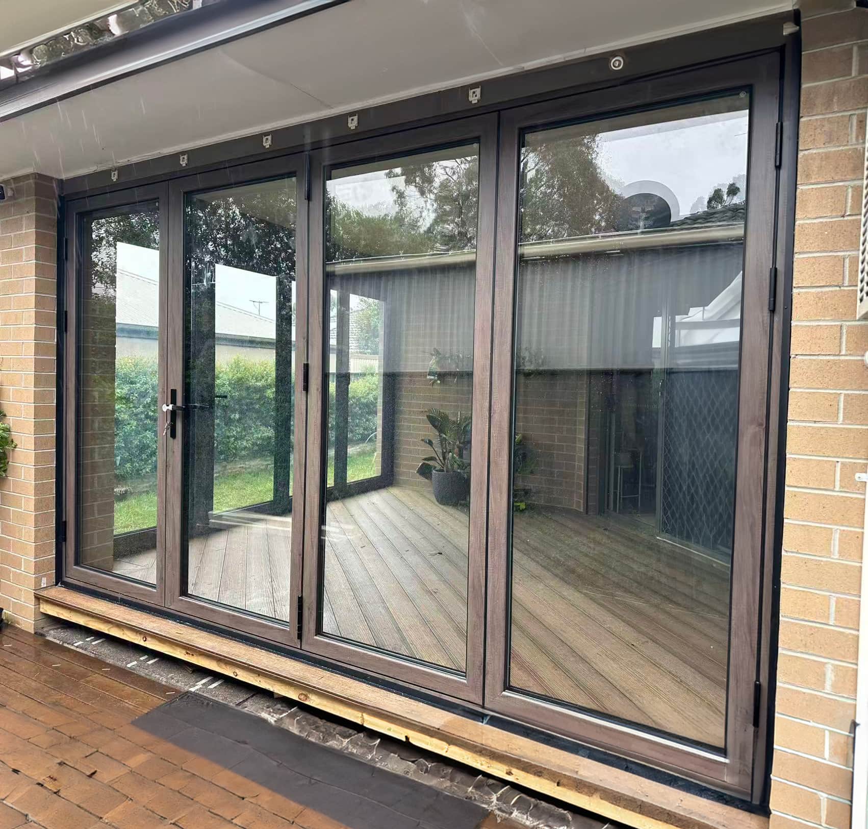 Large-format aluminium sliding glass doors opening onto a deck