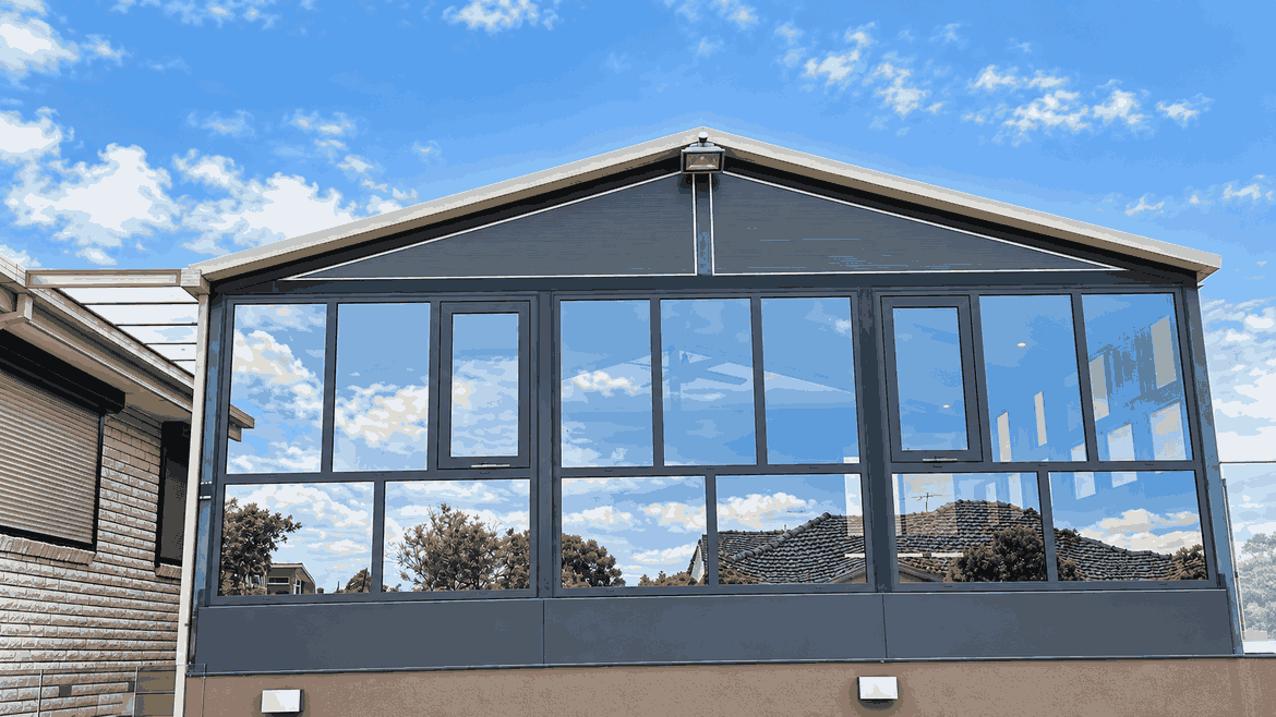 Gabled glass sunroom with dark grey powder-coated aluminium frames