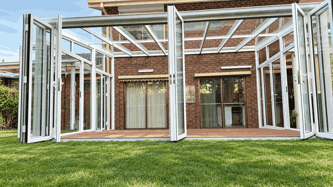Aluminium sunroom with both glass walls fully folded open to the backyard
